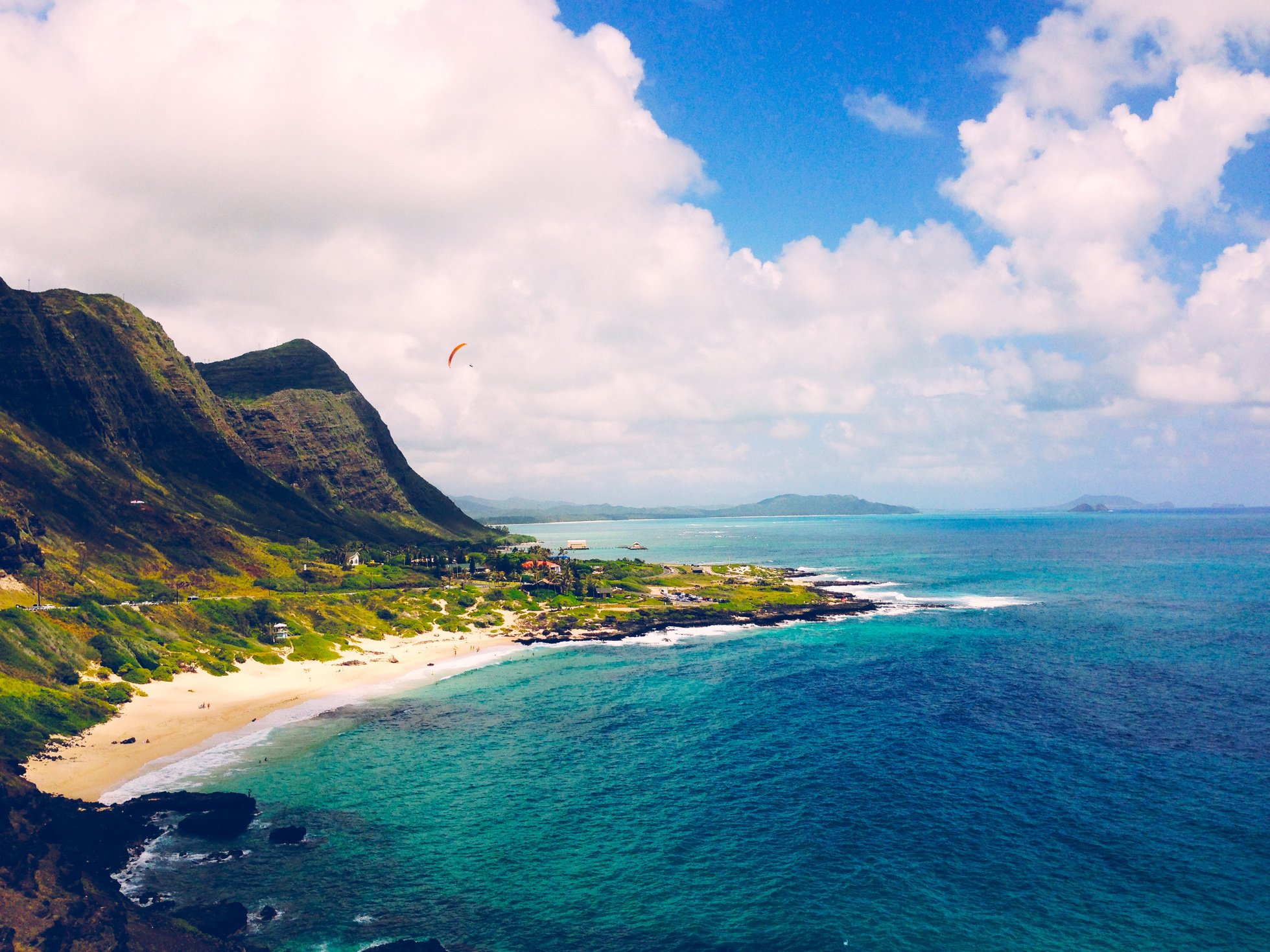 Green Mountains by the Shore Under White Clouds and Blue Sky